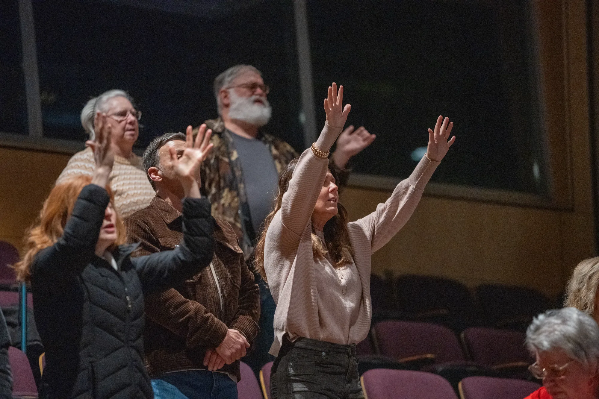 People worshiping with hands raised during a Crossroads Sunday service